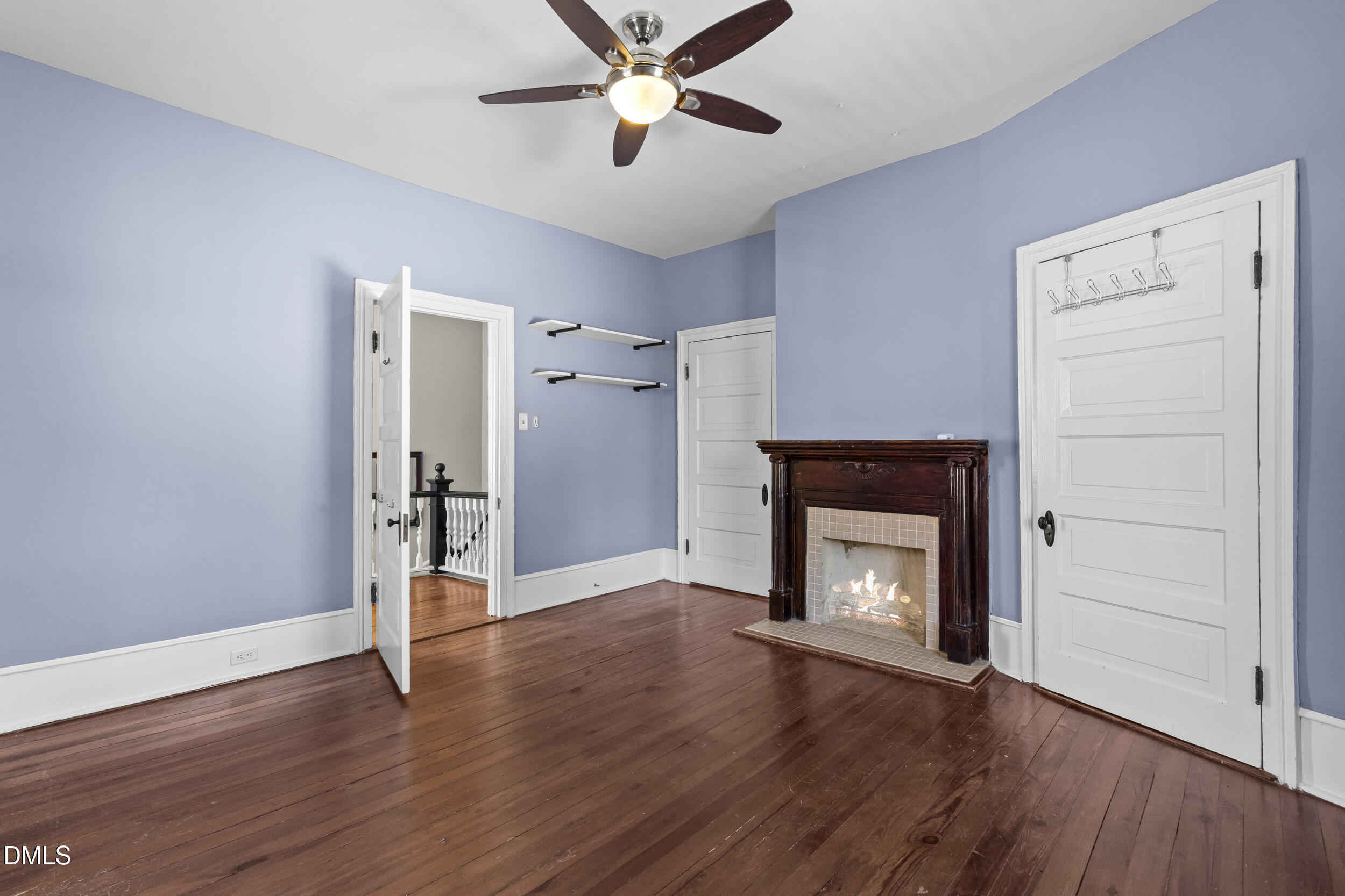 527 North East Street Raleigh, NC 27604 - Photo 26 of 46 an empty room with wooden floor a ceiling fan a fireplace and windows