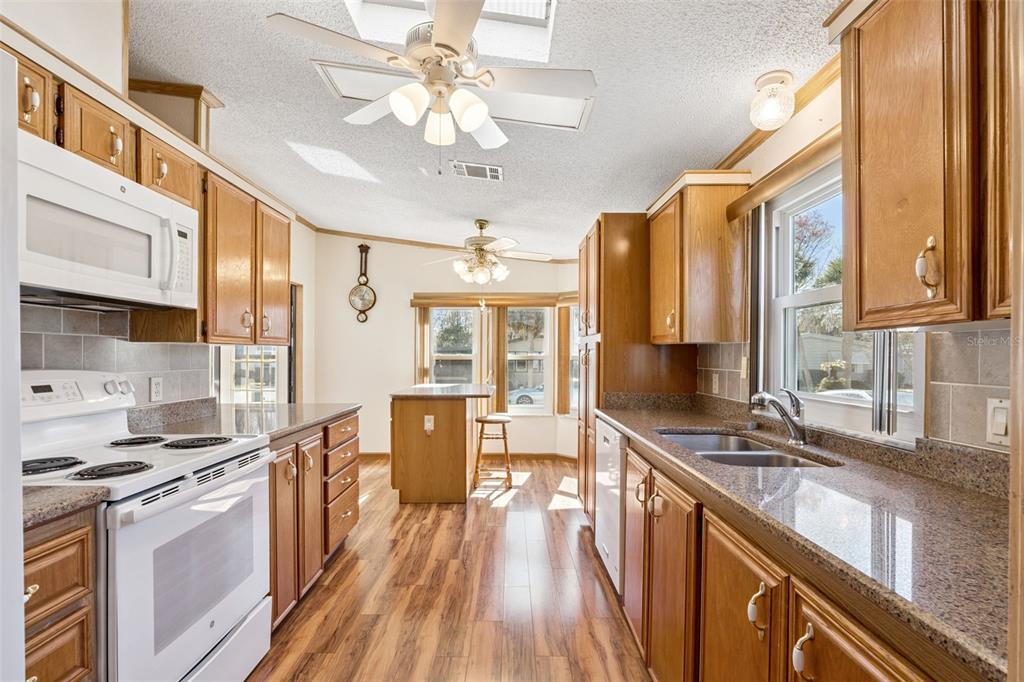 3122 Myakka River Road Tavares, FL 32778 - Photo 8 of 44 a kitchen with stainless steel appliances a stove cabinets and wooden floor