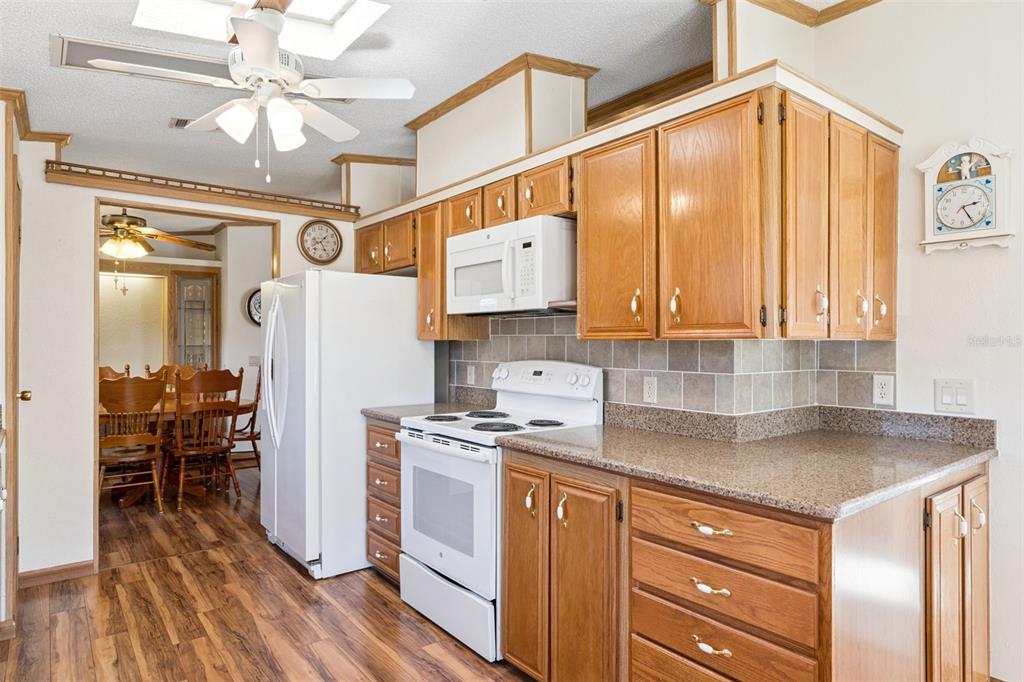 3122 Myakka River Road Tavares, FL 32778 - Photo 9 of 44 a kitchen with stainless steel appliances granite countertop a refrigerator a sink and white cabinets