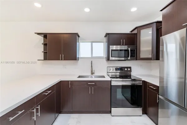 a kitchen with stainless steel appliances granite countertop a sink and a stove