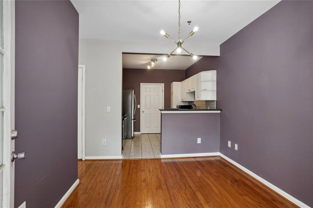 206 Spring Heights Lane, Unit 206 Smyrna, GA 30080 - Photo 19 of 29 an empty room with wooden floor and kitchen view