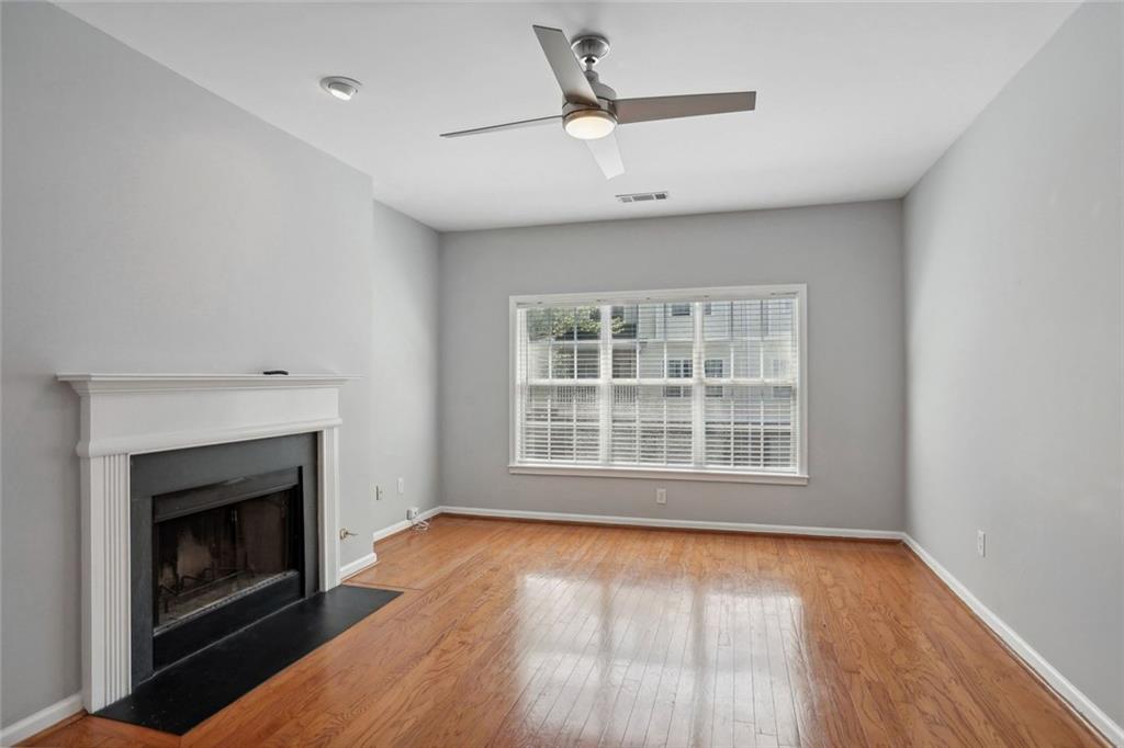 206 Spring Heights Lane, Unit 206 Smyrna, GA 30080 - Photo 8 of 29 an empty room with wooden floor a fireplace and windows