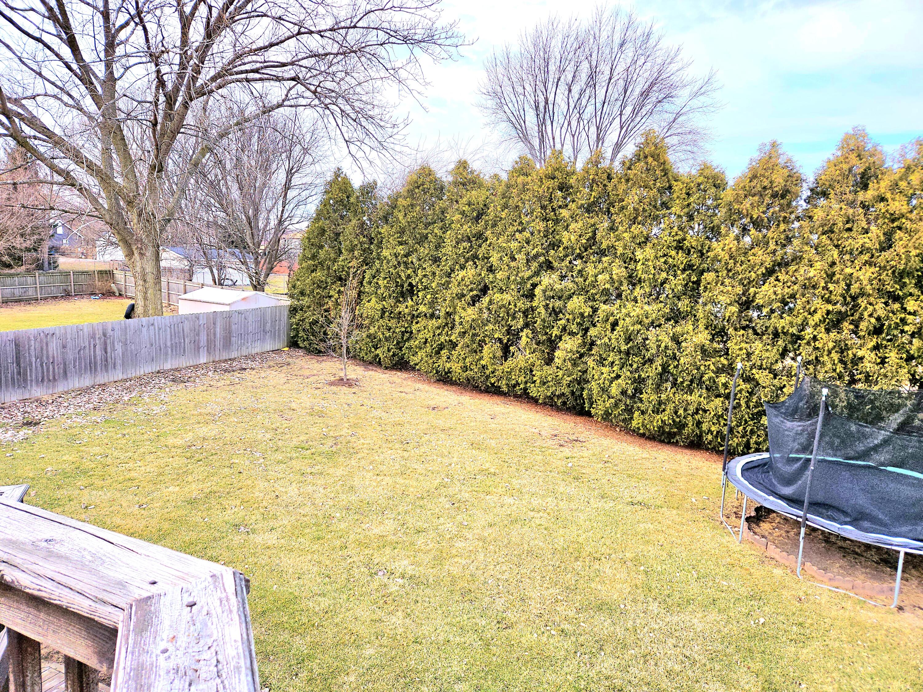 1518 West 96th Place Crown Point, IN 46307 - Photo 37 of 42 a backyard of a house with large trees and wooden fence