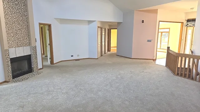 an empty room with windows and fireplace