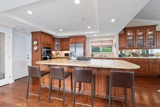 a kitchen with stainless steel appliances granite countertop a table chairs sink refrigerator and microwave