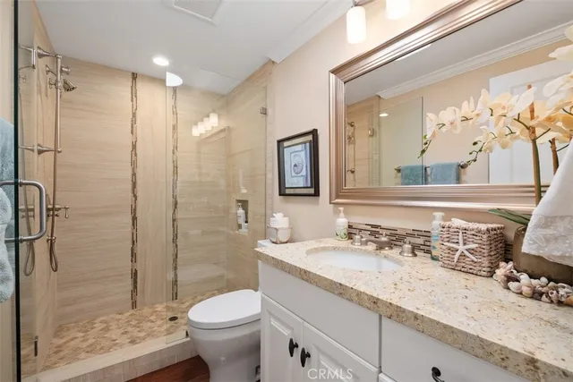 a bathroom with a granite countertop sink toilet and shower