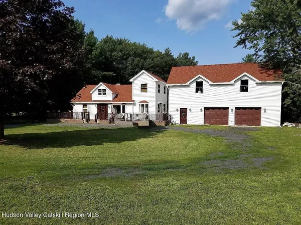 a view of house with garden space and tall tree