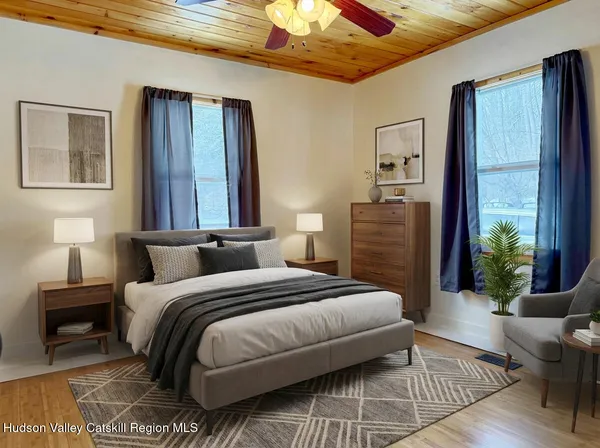 a bedroom with a bed wooden floor and window
