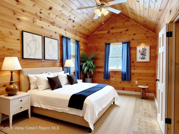 a bedroom with a large bed and a lamp on dresser