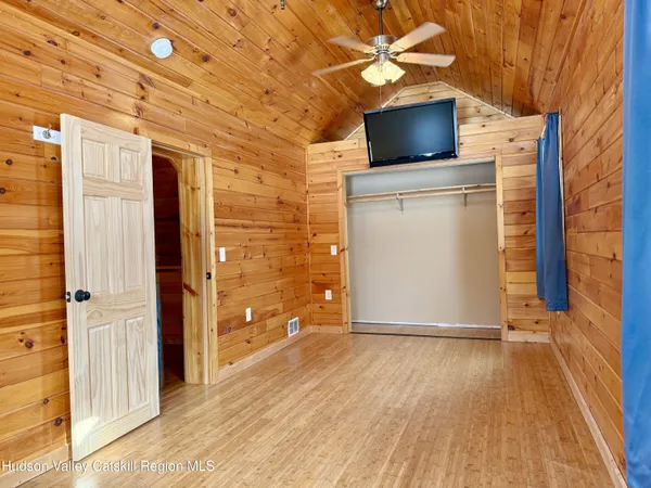 a view of a livingroom with wooden floor and a ceiling fan