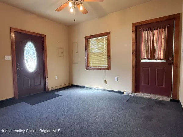 an empty room with windows cabinet and mirror