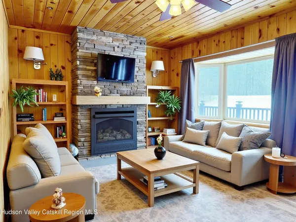 a living room with furniture a fireplace and a large window