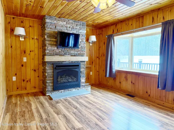 a view of a livingroom with wooden floor a fireplace and window