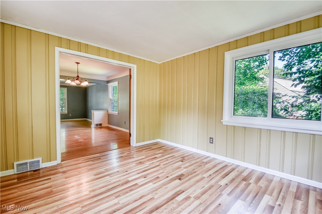 2607 Ashurst Road University Heights, OH 44118 - Photo 21 of 39 Spare room featuring ornamental molding, a chandelier, and light wood finished floors