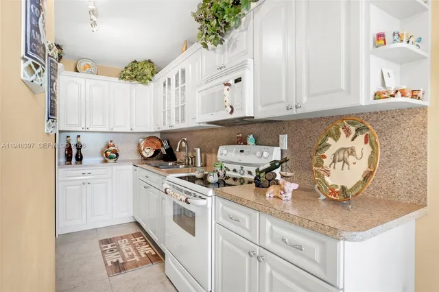 a kitchen with granite countertop a white cabinets and white appliances