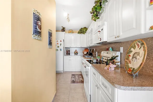 a view of a kitchen with fridge and workspace