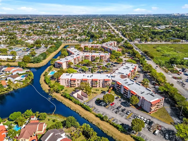 an aerial view of a city with lots of residential buildings ocean and mountain view in back
