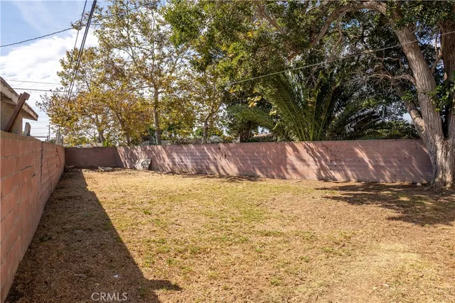 a view of a yard with wooden fence