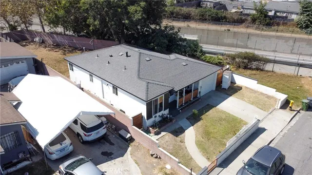 aerial view of a house with wooden deck and furniture