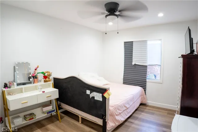 a bedroom with a bed and wooden floor