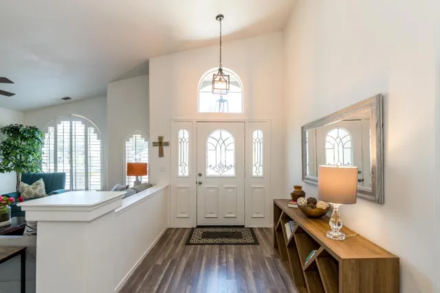 a dining room with wooden floor a chandelier a wooden table and chairs