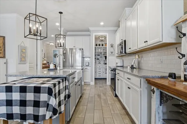 a kitchen with stainless steel appliances granite countertop a sink a stove and a refrigerator