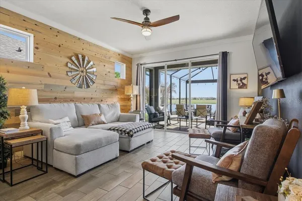 a living room with furniture ceiling fan and a flat screen tv