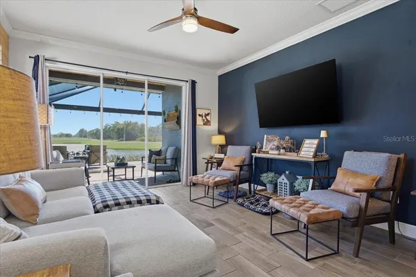 a living room with furniture a flat screen tv and a floor to ceiling window