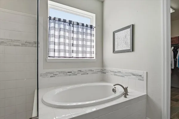 a white bath tub sitting in a bathroom next to a window