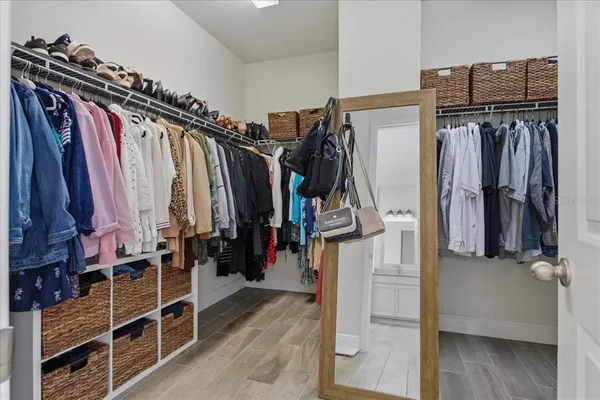 a walk in closet with clothes