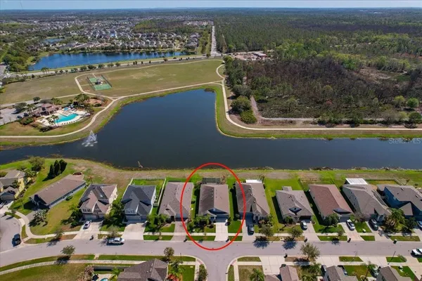 an aerial view of a house with a garden and lake view