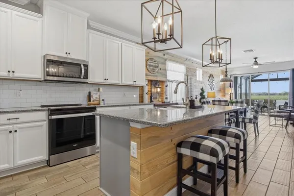 a kitchen with stainless steel appliances granite countertop a stove a sink and a microwave