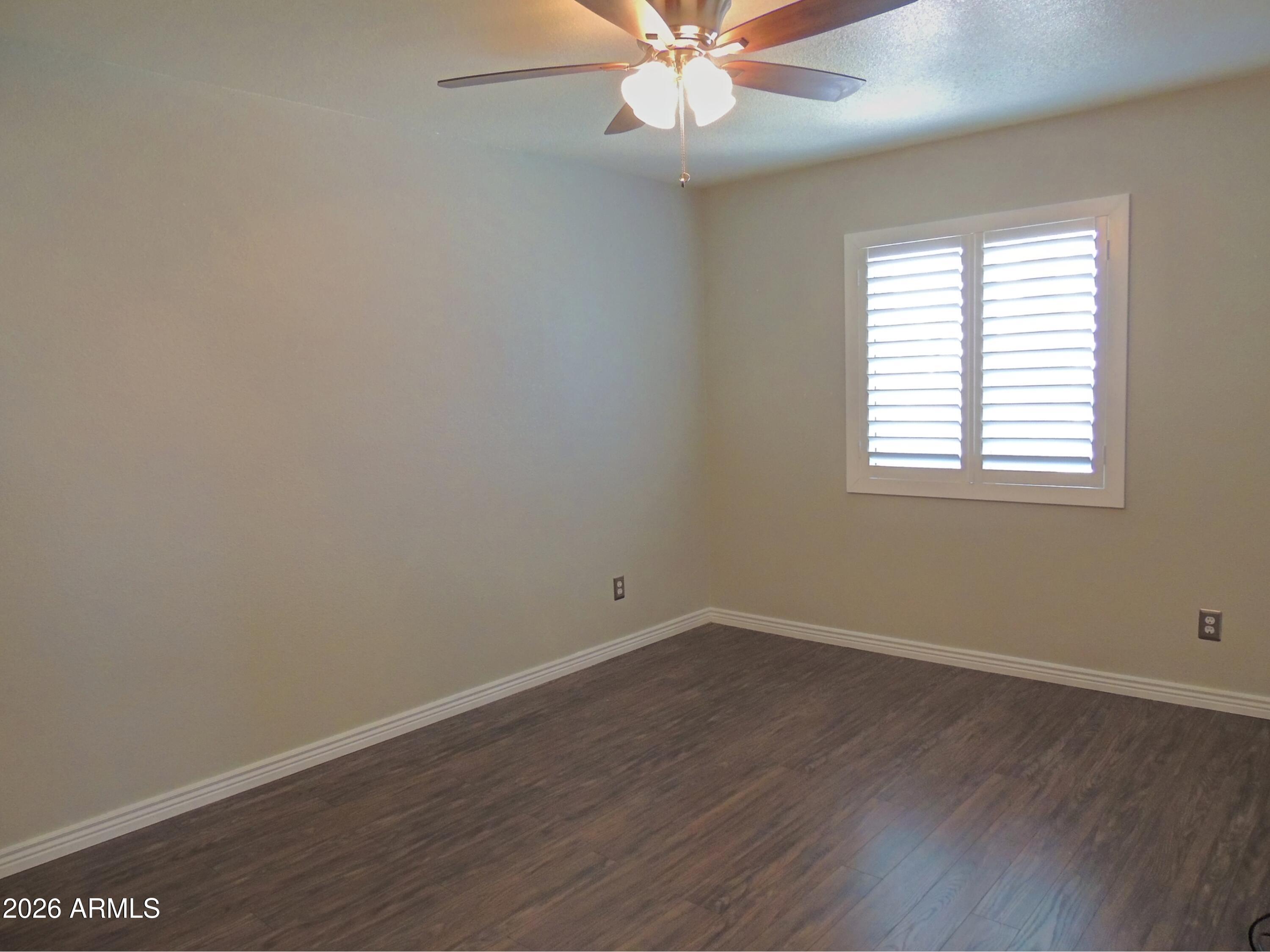 4409 East Dry Creek Road Phoenix, AZ 85044 - Photo 24 of 34 an empty room with wooden floor fan and windows