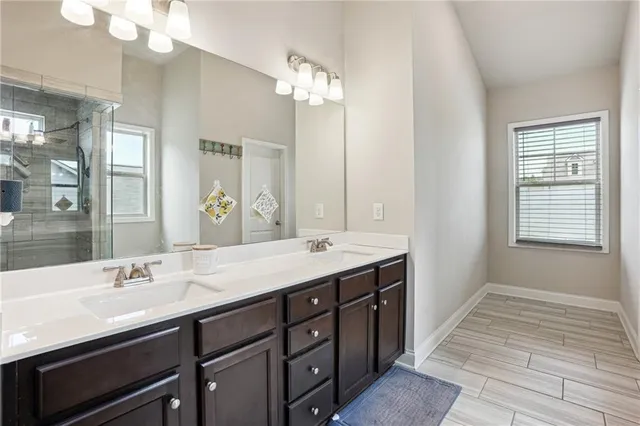 a bathroom with a sink a toilet a mirror and shower