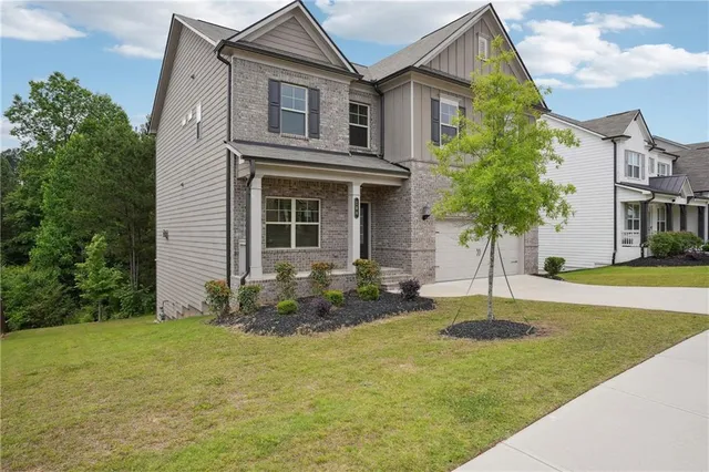 a front view of house with yard and trees around