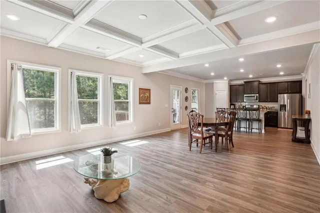 a dining room with wooden floor a glass table and chairs