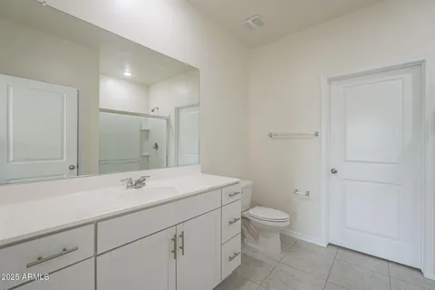 a bathroom with a sink a toilet and a large mirror