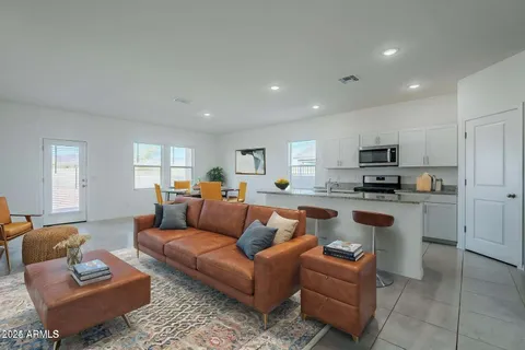 a living room with furniture kitchen and a table