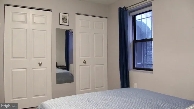 a bedroom with a bed and a mirror