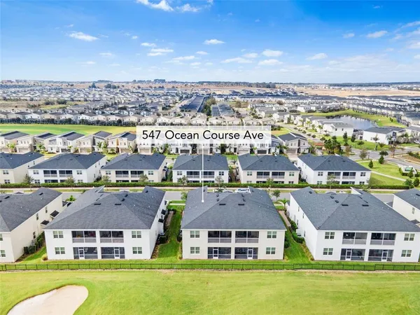 an aerial view of multiple houses with a big yard