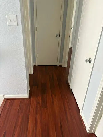 a view of a hallway and wooden floor