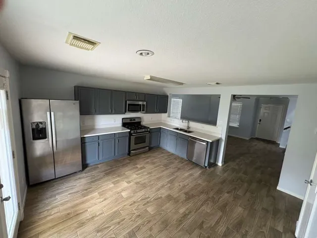 a kitchen with stainless steel appliances a refrigerator and a stove top oven