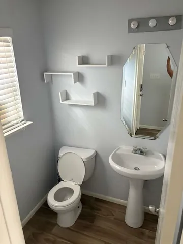 a bathroom with a toilet sink and mirror