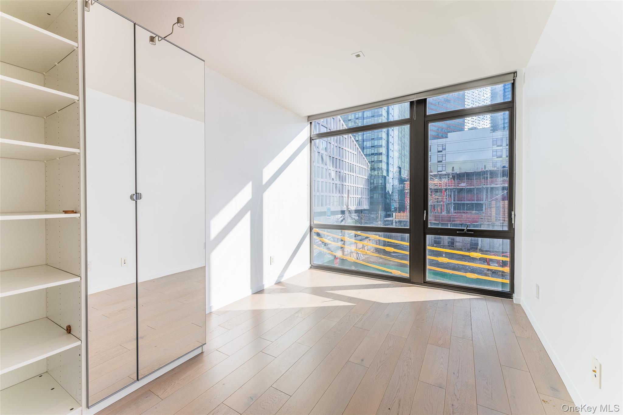 24-12 42nd Road, Unit 3E Queens, NY 11101 - Photo 11 of 24 a view of an empty room with a window