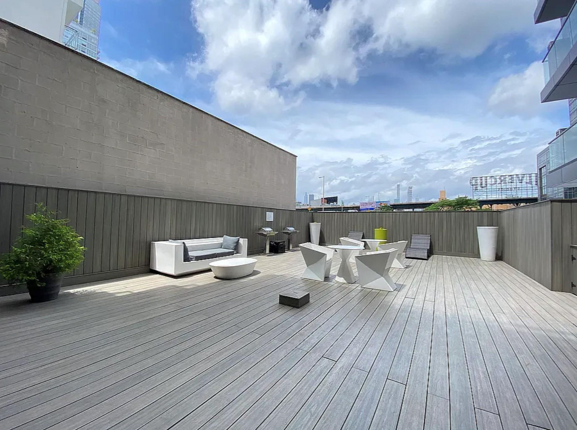 24-12 42nd Road, Unit 3E Queens, NY 11101 - Photo 11 of 13 Wooden deck featuring outdoor dining area