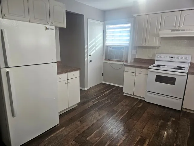 a kitchen with a sink and wooden floor