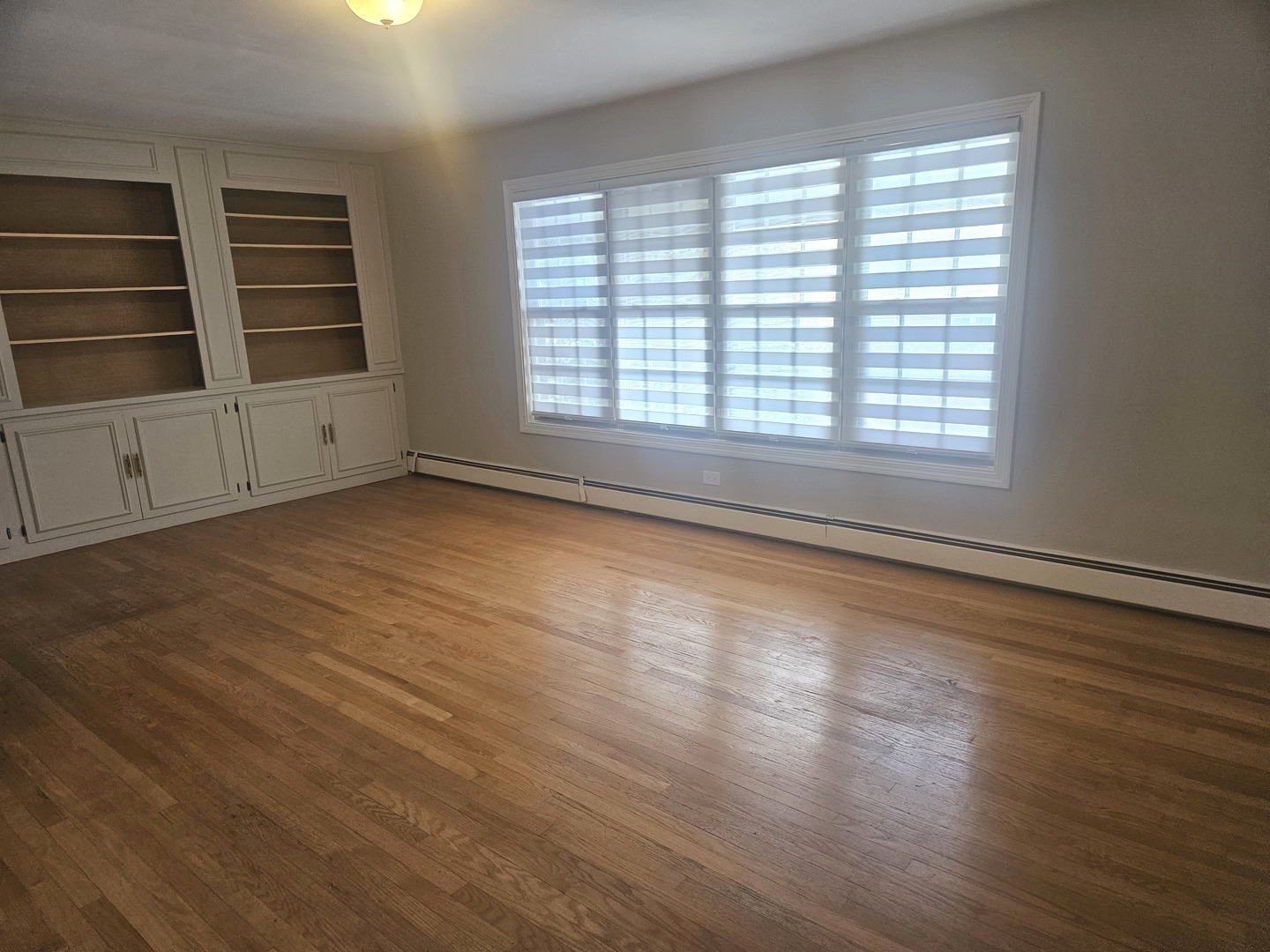 863 North Northwest Highway, Unit 2 Park Ridge, IL 60068 - Photo 9 of 23 a view of an empty room with a window and wooden floor