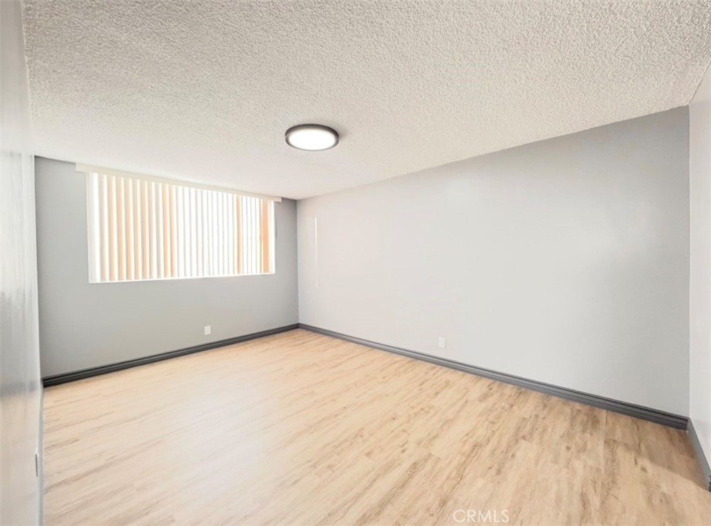 6979 Palm Court, Unit N242 Riverside, CA 92506 - Photo 15 of 27 a view of an empty room with wooden floor and a window
