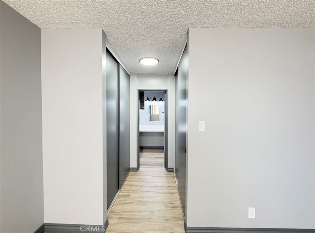 6979 Palm Court, Unit N242 Riverside, CA 92506 - Photo 17 of 27 a view of a hallway with wooden floor and a bathroom