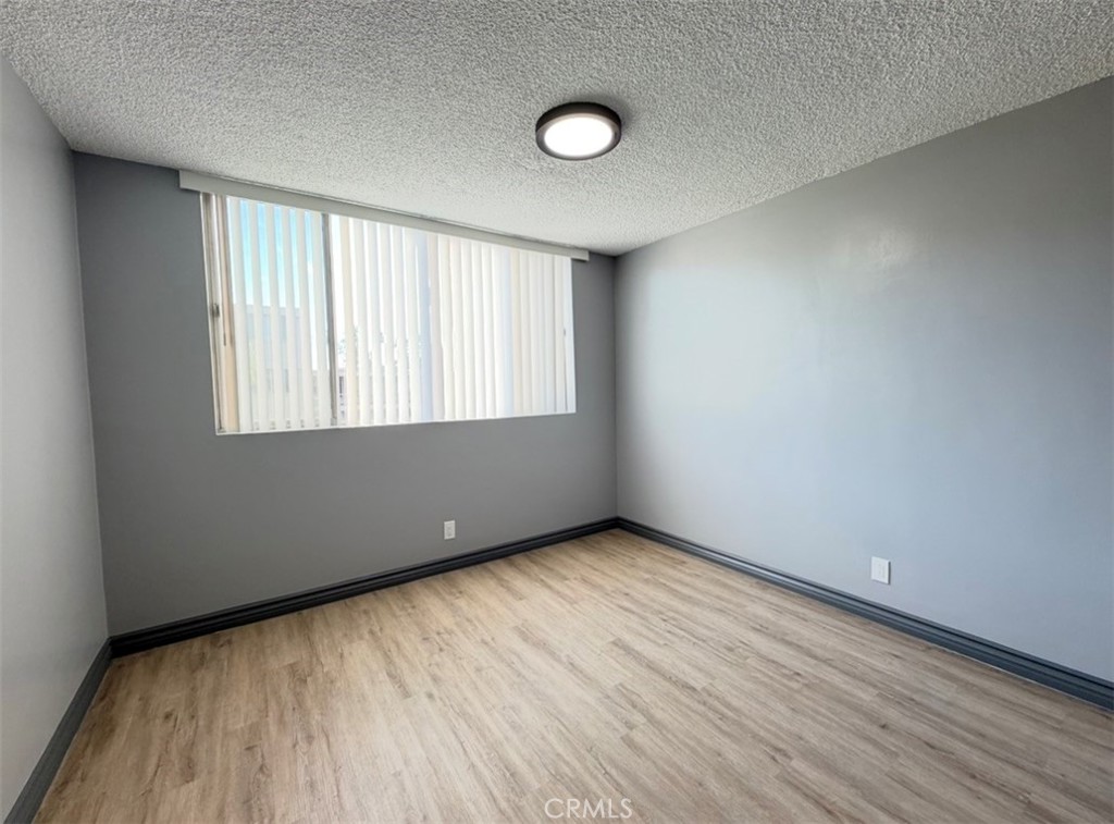 6979 Palm Court, Unit N242 Riverside, CA 92506 - Photo 20 of 27 an empty room with wooden floor and windows
